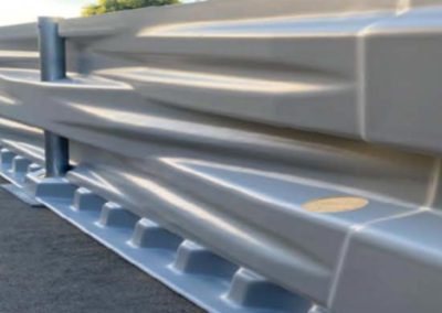 A close-up view of a metal highway guardrail installed along the edge of a paved road.