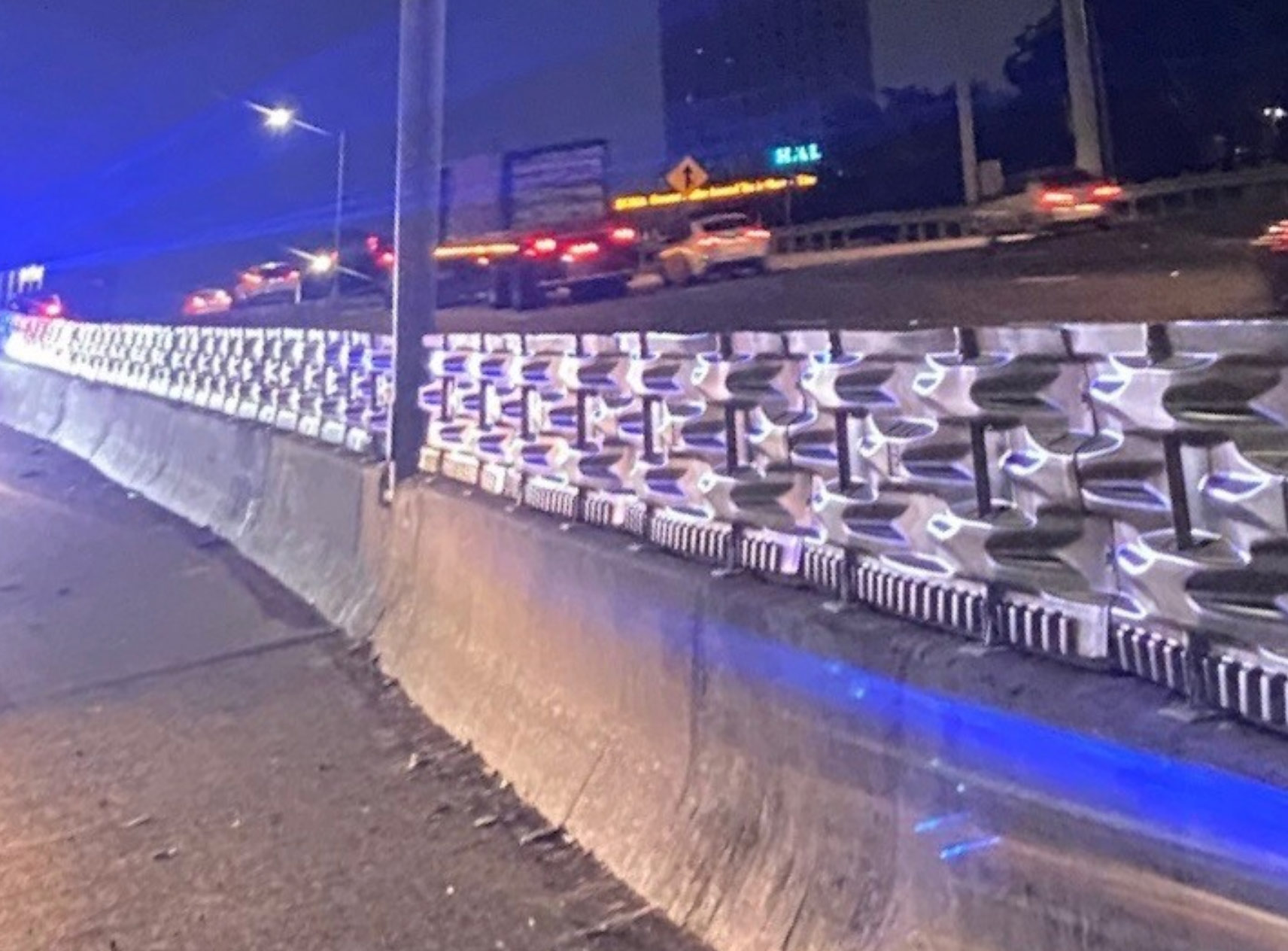 A Pedestrian Barrier shown on a highway at night.