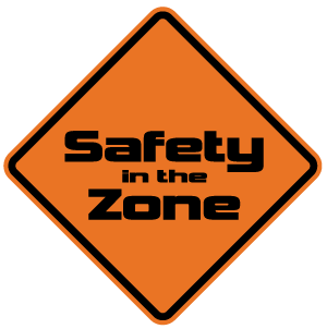 An orange diamond sign with the text "Safety in the Zone" in bold black letters.